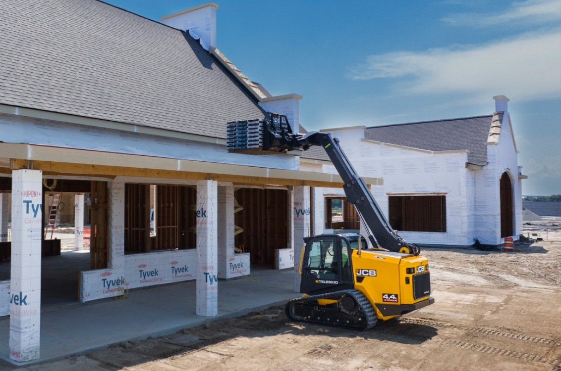 JCB 400T Compact Track Loader lifting roofing material