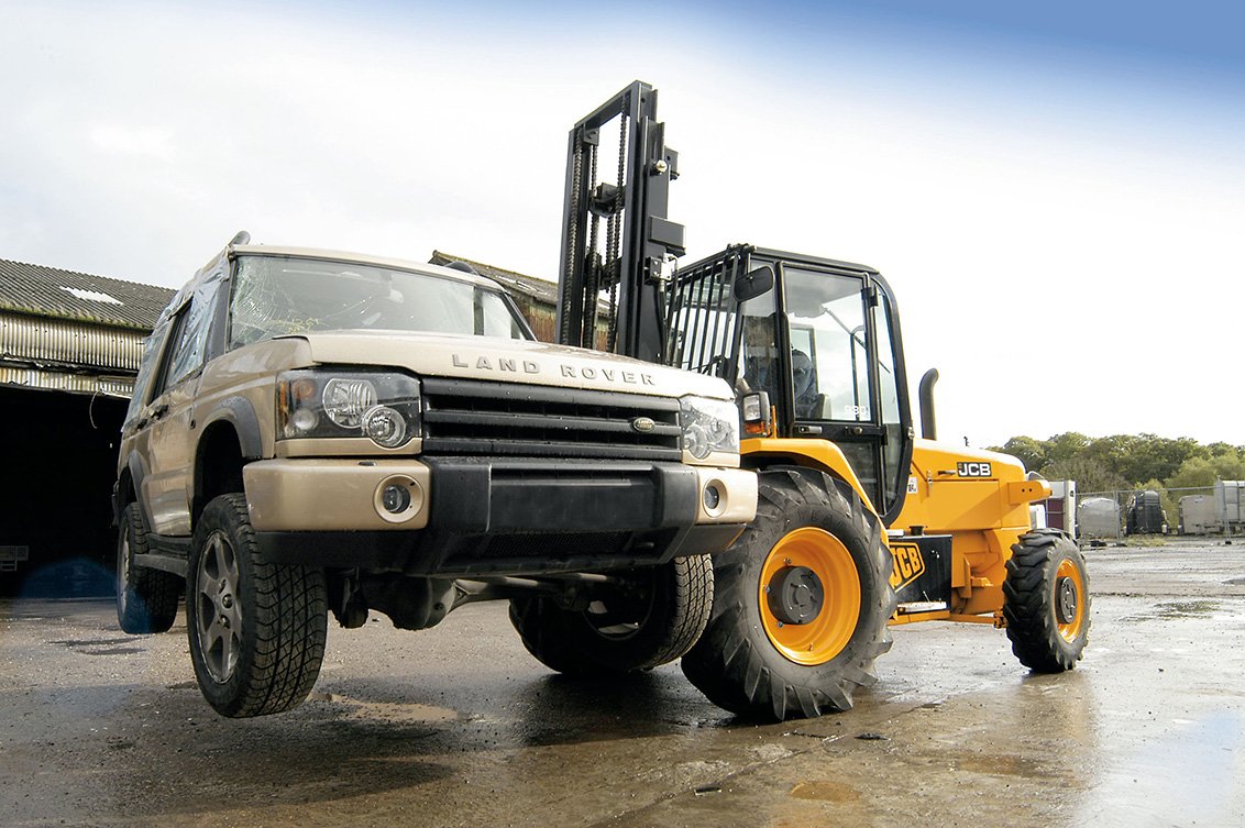 JCB 930 Rough Terrain Forklift moving a car