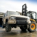 JCB 930 Rough Terrain Forklift moving a car