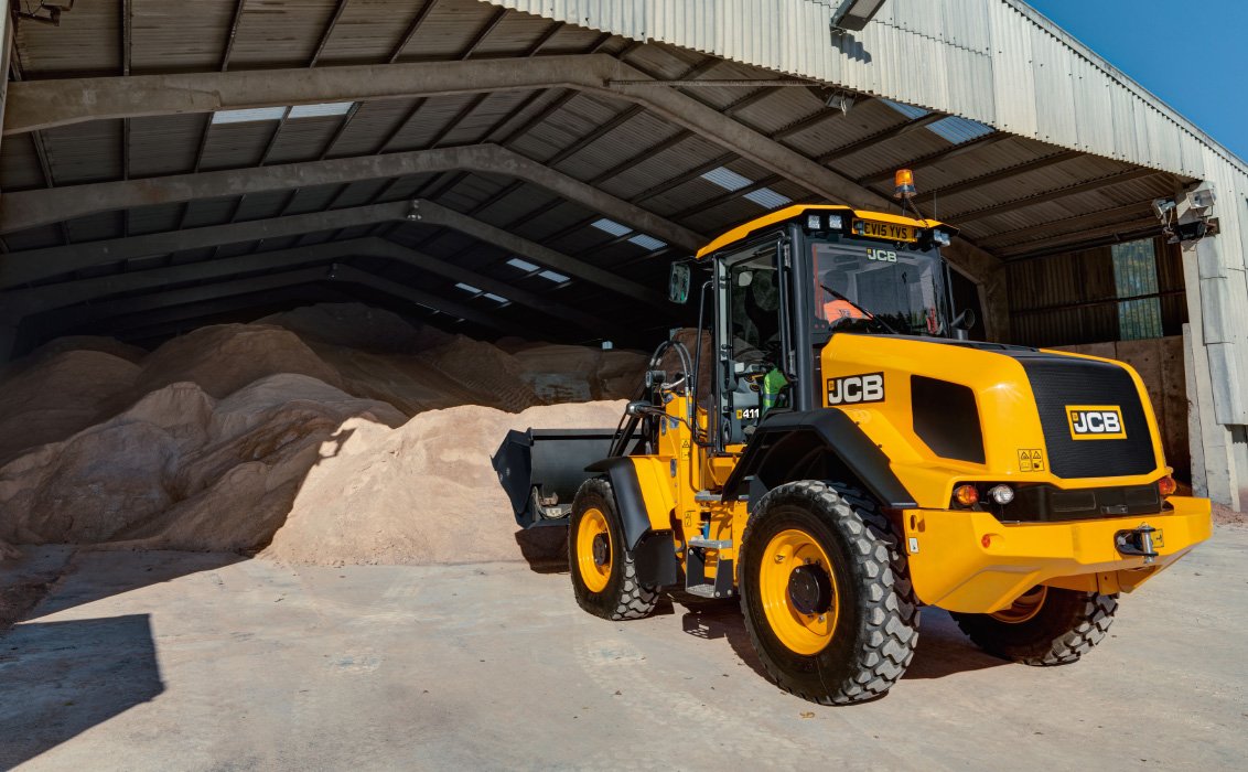 JCB 411 Wheel Loader scooping up a bucket of sand