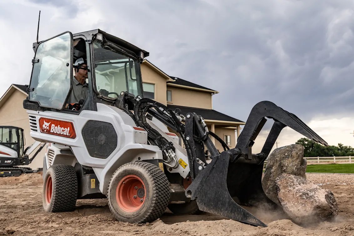 Bobcat L28 Small Articulated Loader moving landscape rocks