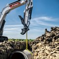 Bobcat E88 Mini Excavator dropping pipe into trench