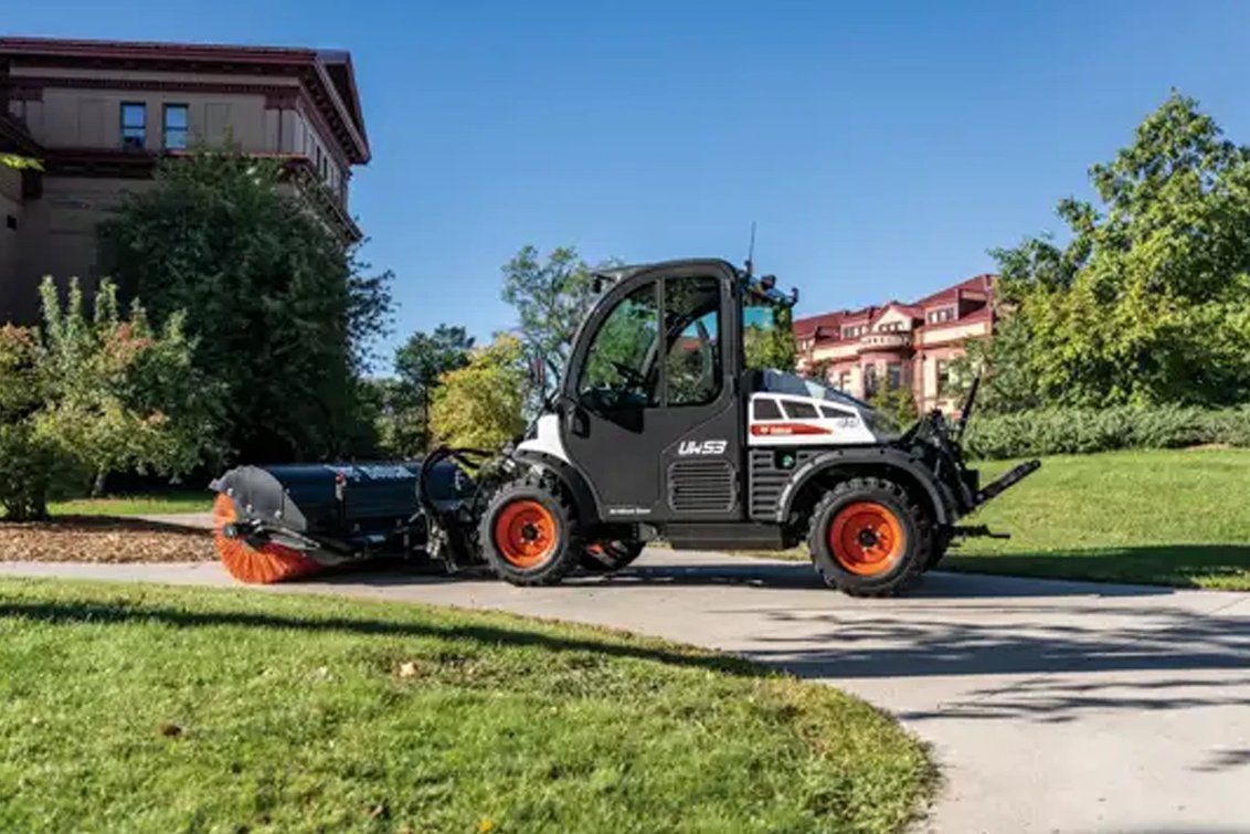 Bobcat UW53 Toolcat sweeping a sidewalk