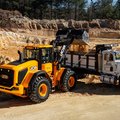 JCB 437 Wheel Loader releasing a load of dirt into dump truck