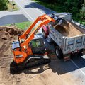 DEVELON DTL30 Compact Track Loader dumping a load of dirt into a truck