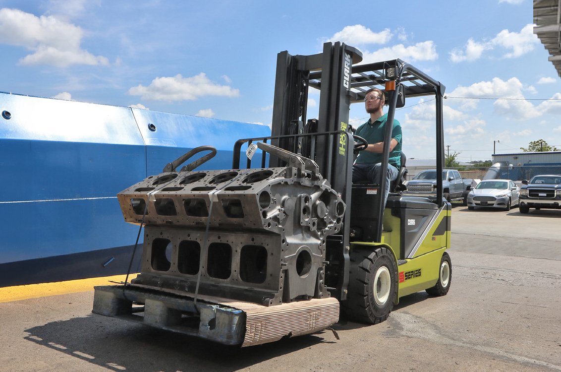 Clark SE35 Electric Rider Pneumatic Forklift moving a large heavy engine