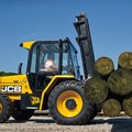 JCB 930 Rough Terrain Forklift hauling large full-size logs