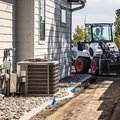 Bobcat L35 Small Articulated Loader with pallet fork attachment in tight work area