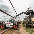 Bobcat TL723 Telehandler unloading farm waste into a container