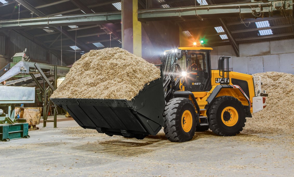 JCB 427 Wheel Loader hauling wood shavings