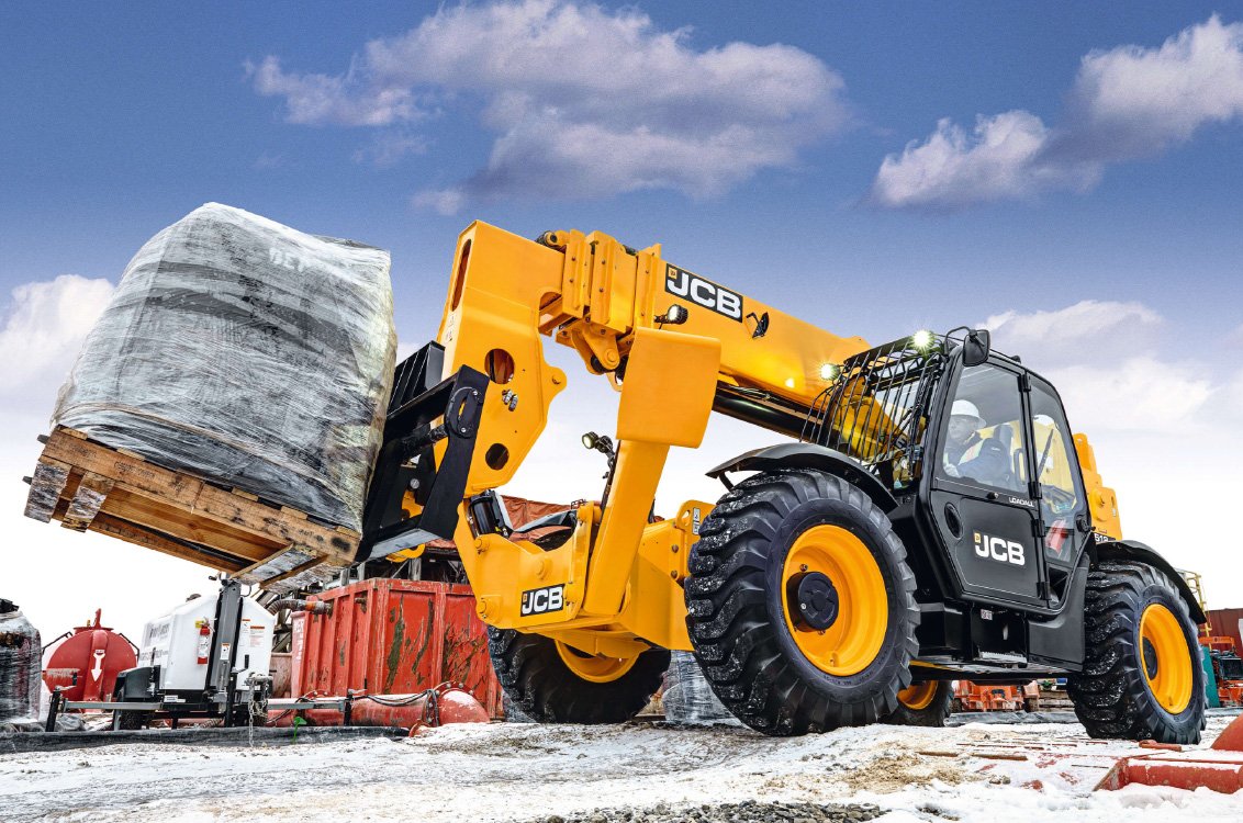 JCB 512-56 Telehandler hauling a heavy load on a construction site