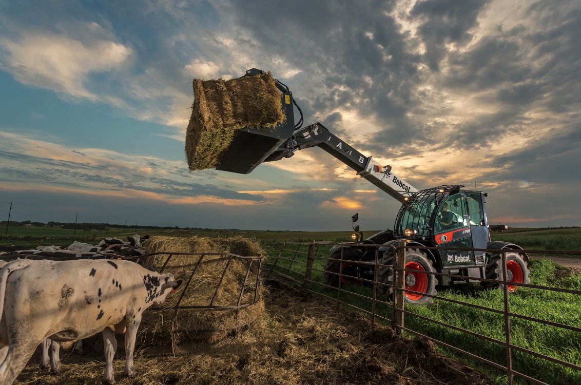 Bobcat TL723 Telehandler unloading a large hay bail on a ranch