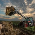 Bobcat TL723 Telehandler unloading a large hay bail on a ranch