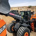 DEVELON DL550-7 Wheel Loader dumping load into DEVELON articulated dump truck
