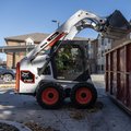 Bobcat S450 Skid Steer Loader dumping scrap into a container