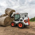 Bobcat S650 Skid Steer Loader stacking hay rolls