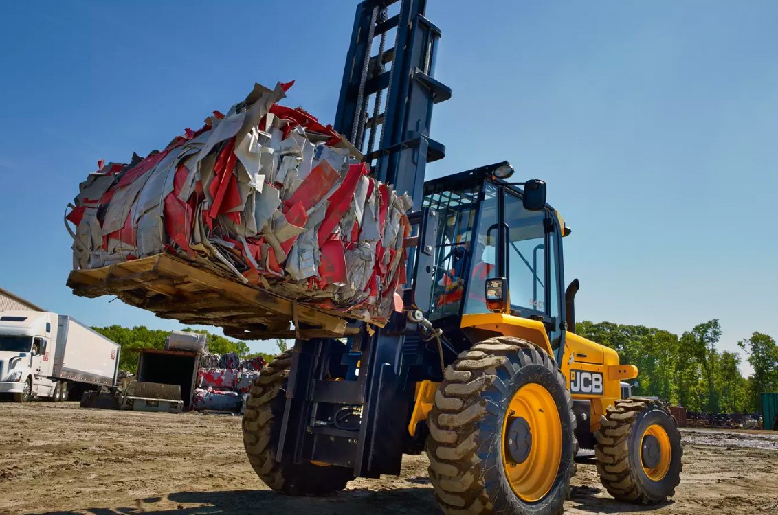 JCB 940 Rough Terrain Forklift hauling a heavy trash bail