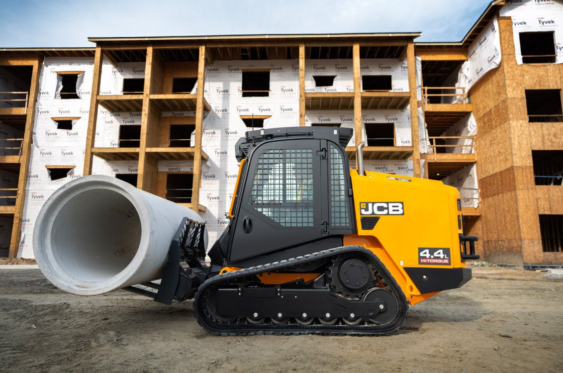 JCB 400T Compact Track Loader carrying heavy cement pipe