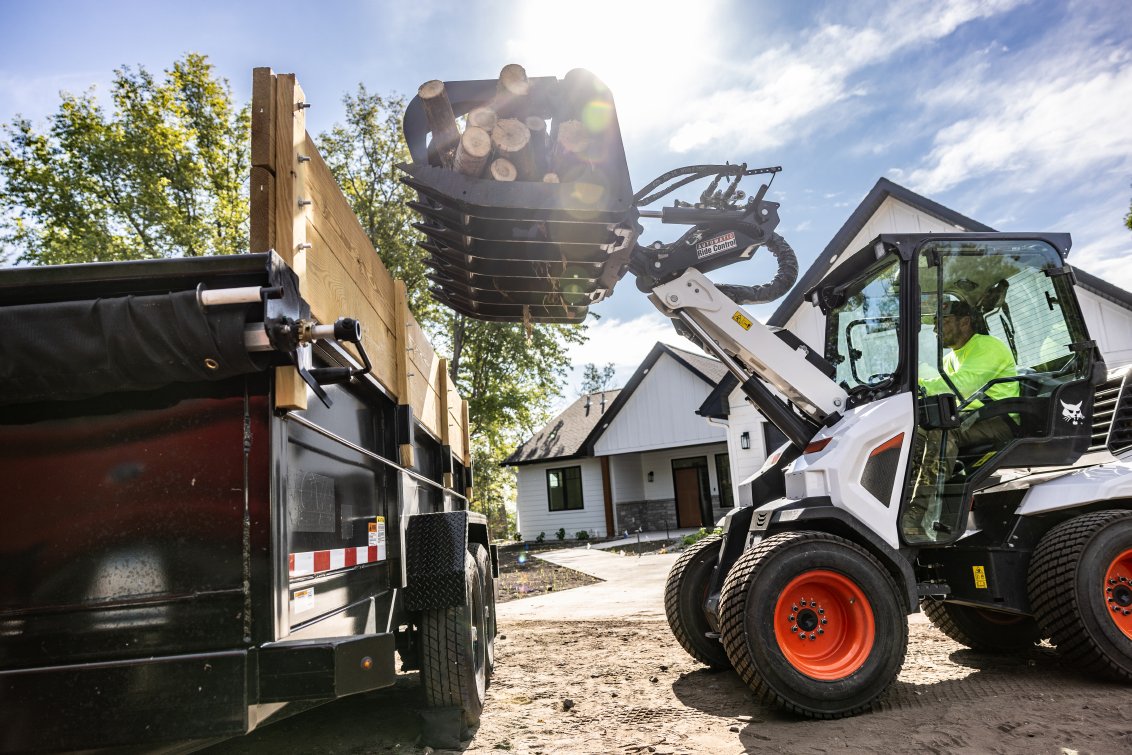 Bobcat L35 Small Articulated Loader dumping debris with a root grappler attachment
