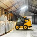 JCB 3TS-8W Teleskid Skid Steer Loader moving feed bags on a farm