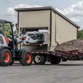 Bobcat L65 Compact Wheel Loader carrying concrete bricks