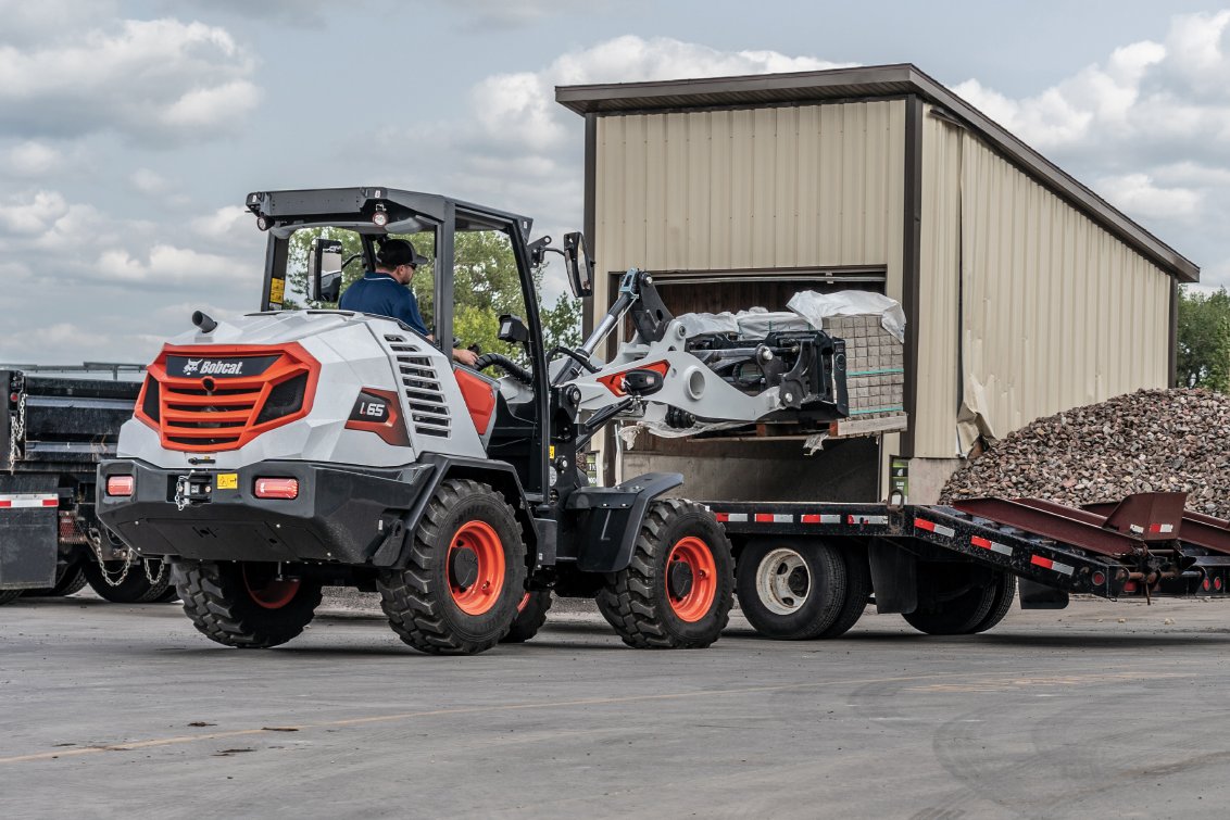 Bobcat L65 Compact Wheel Loader carrying concrete bricks