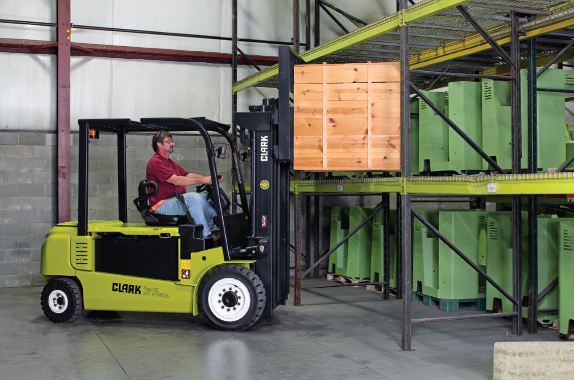 Clark GEX50 Electric Rider Pneumatic Forklift loading a large heavy box on the rack