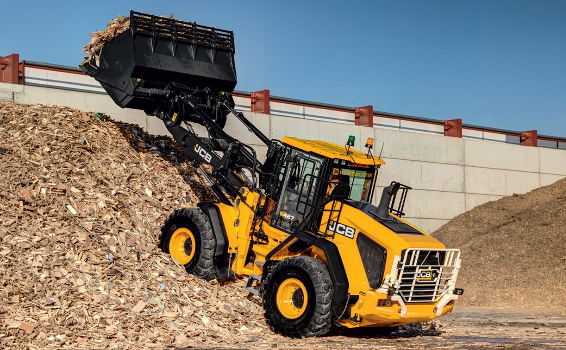 JCB 427 Wheel Loader movings wood scrap
