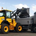 JCB 411 Wheel Loader dumping a load of dirt into a truck