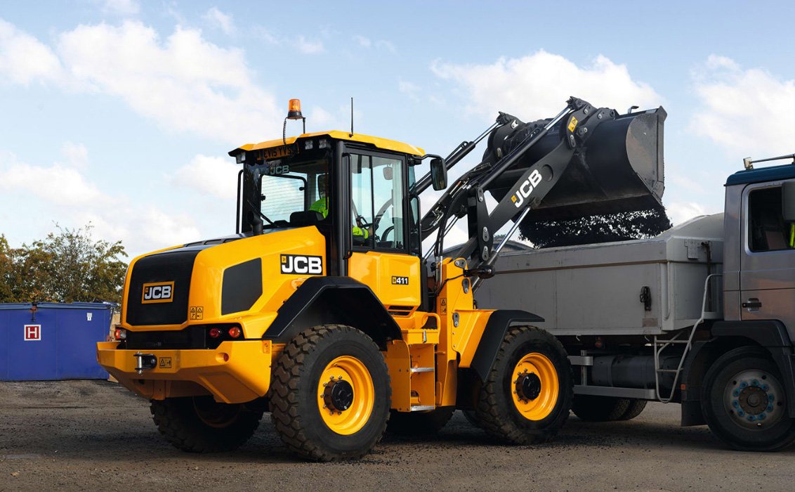JCB 411 Wheel Loader dumping a load of dirt into a truck