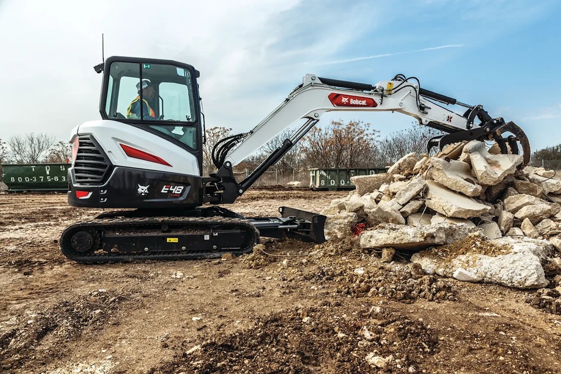Bobcat E48 Mini Excavator moving scrap cement